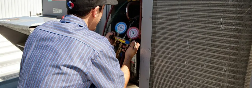 HVAC technician servicing a condenser unit in Southern Pines