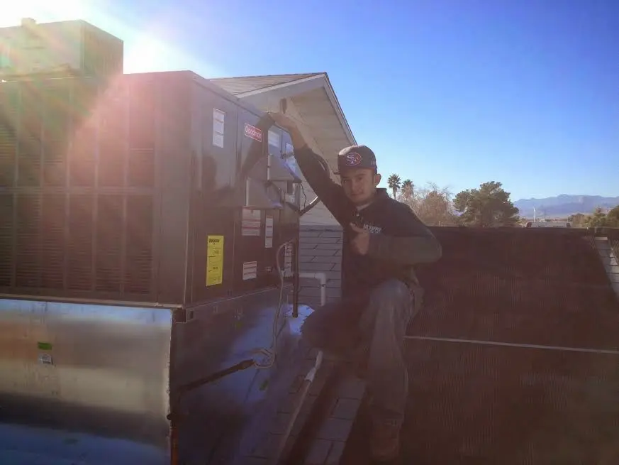 HVAC technician performing AC Tune-Up on a rooftop unit in Southern Pines